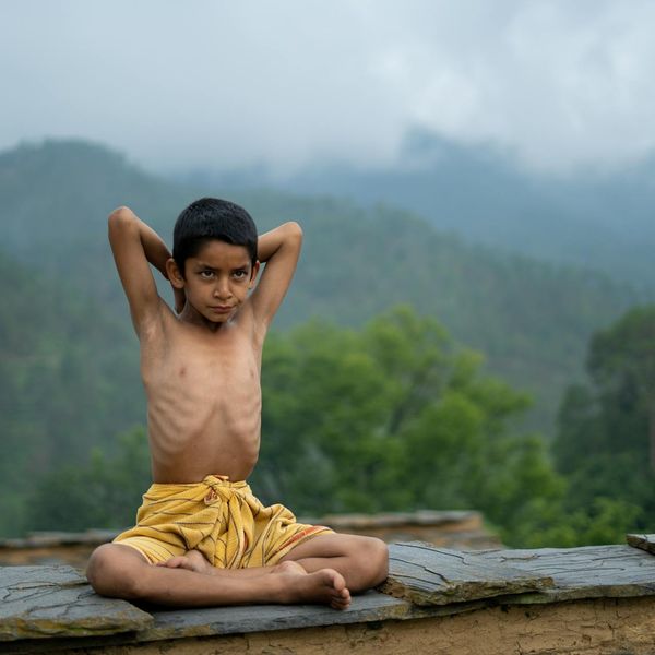 Person practicing deep breathing exercises in a tranquil nature setting.